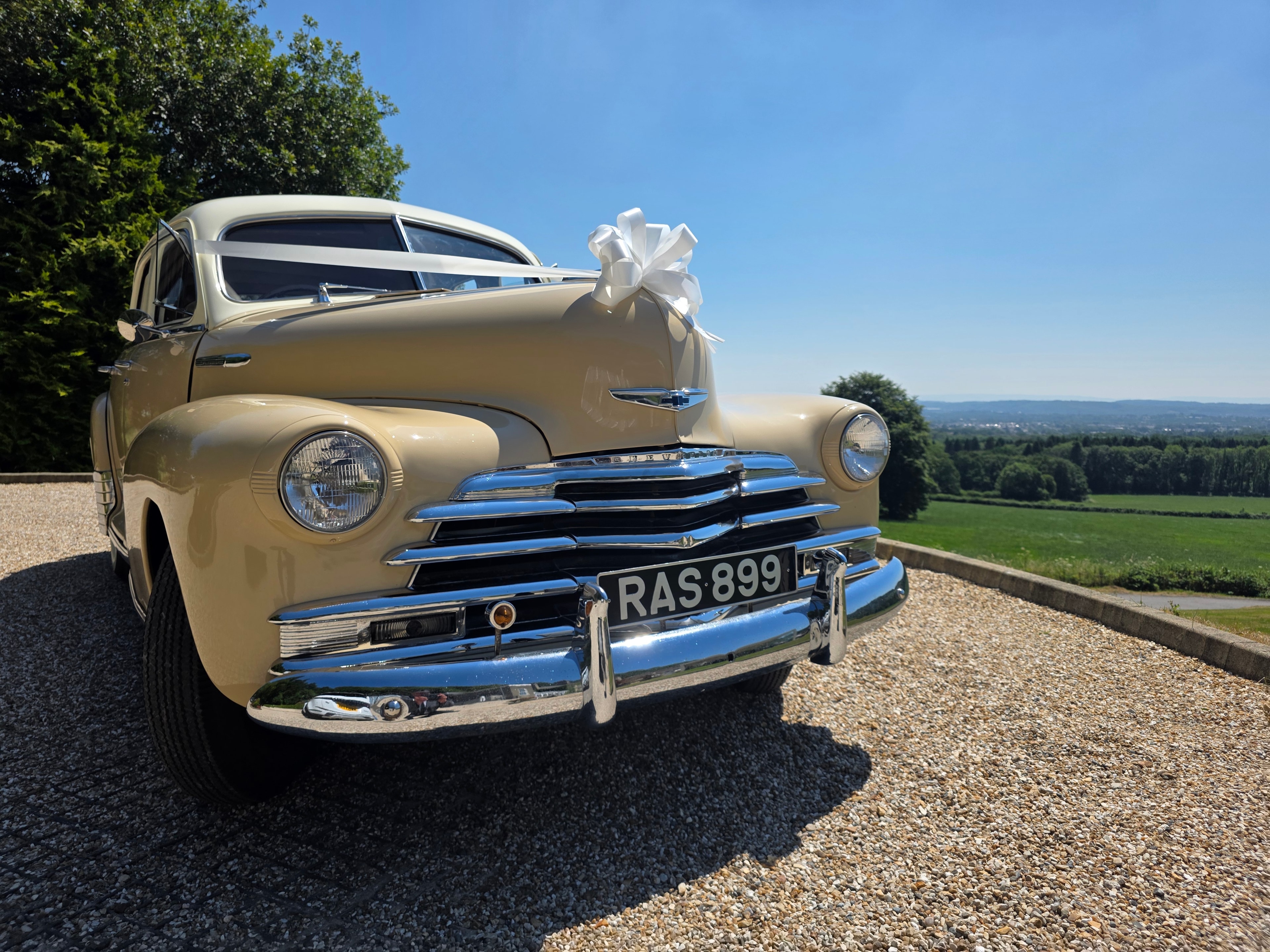 Cream vintage wedding car decorated with ribbons